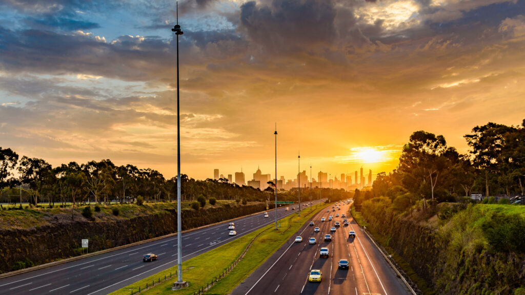 A picture depicting a roadway filled with vehicles under the morning sun.